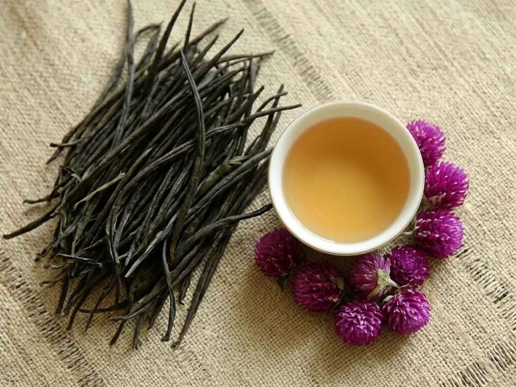 Ceylon golden tips tea leaves with a cup of golden-amber tea, handmade in Kandy, Sri Lanka